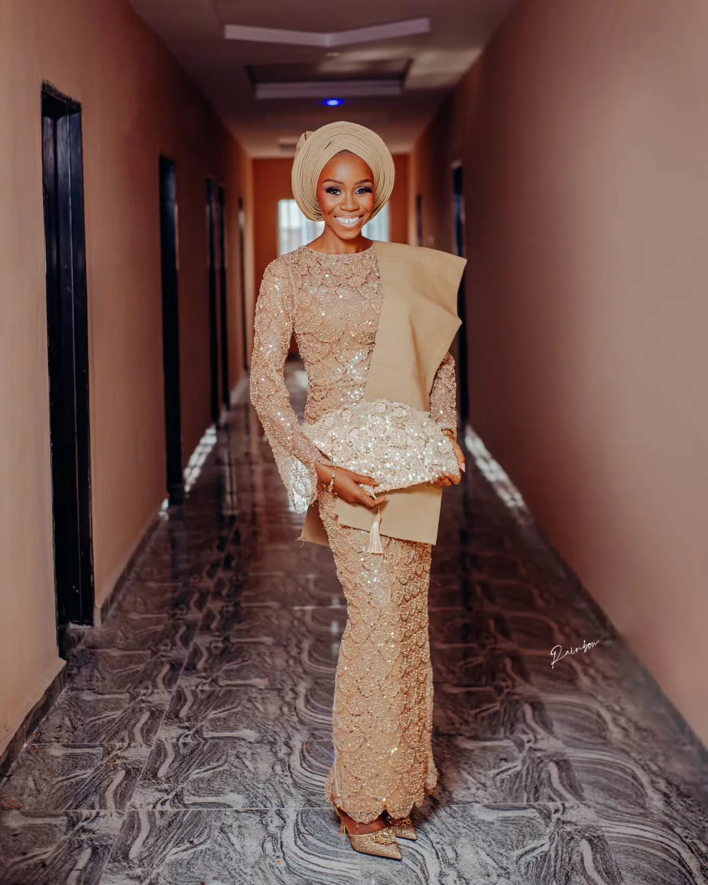 Bride walking down a softly lit corridor in gold lace