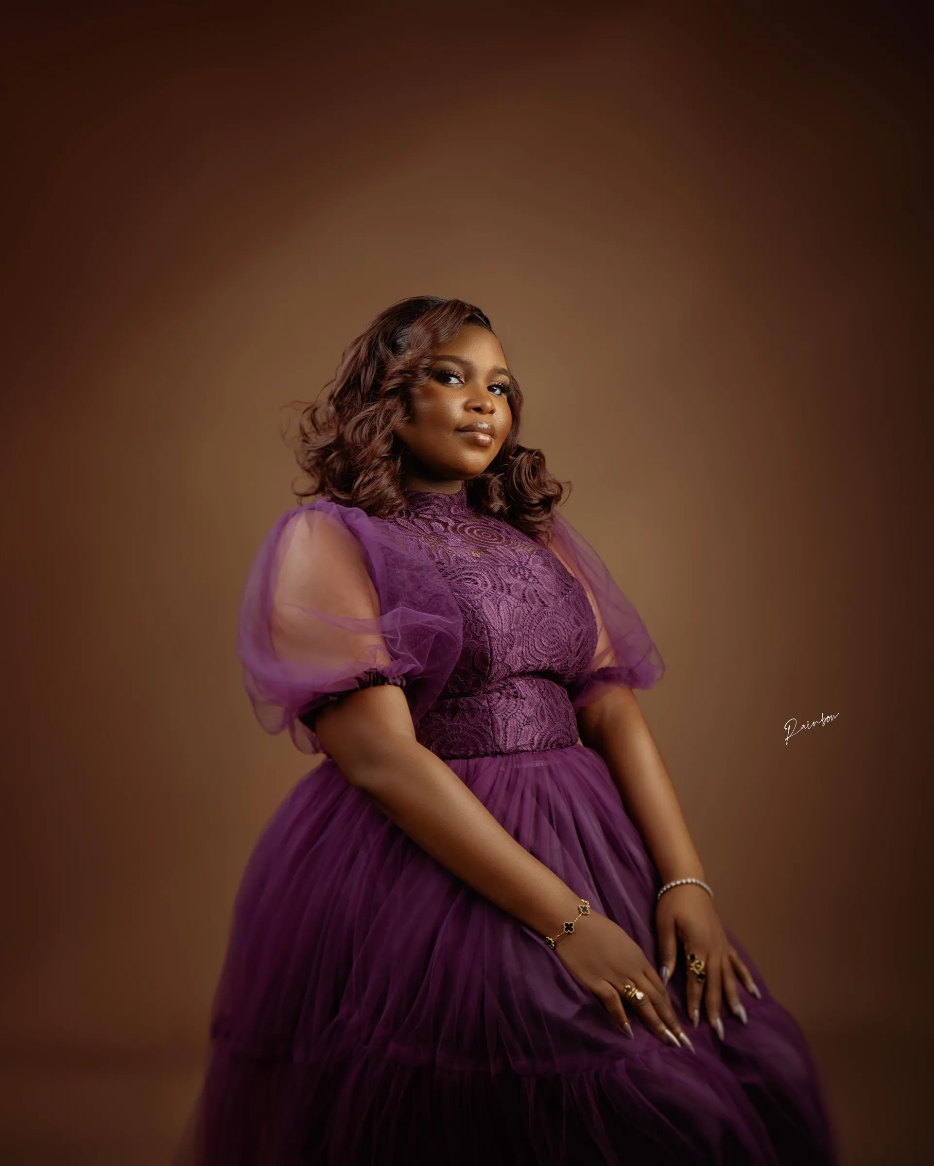 Woman in purple seated, looking away