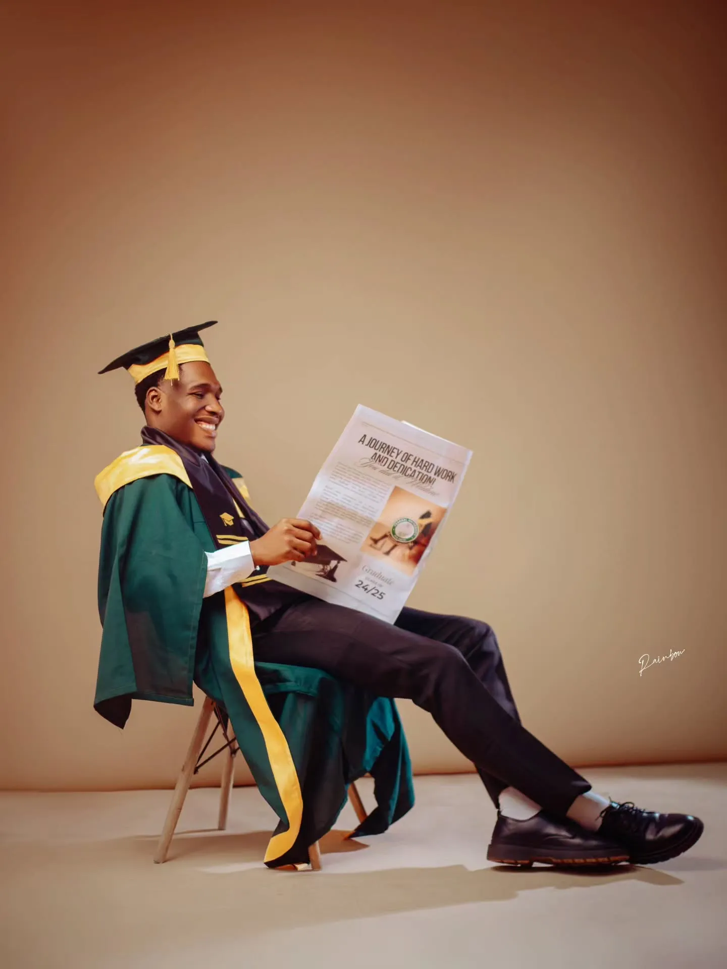 Graduate reading a newspaper in a green gown