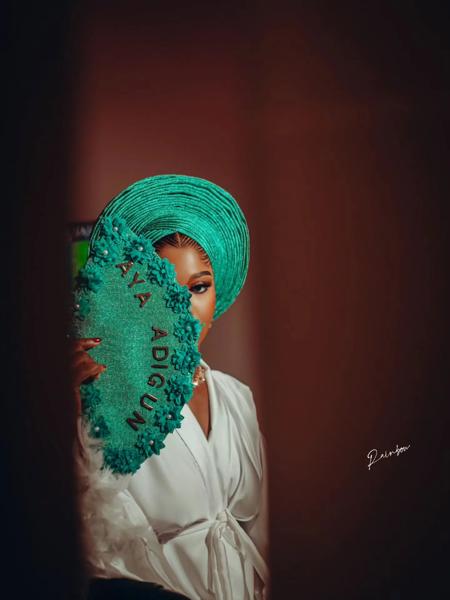 Bride glancing over her emerald fan
