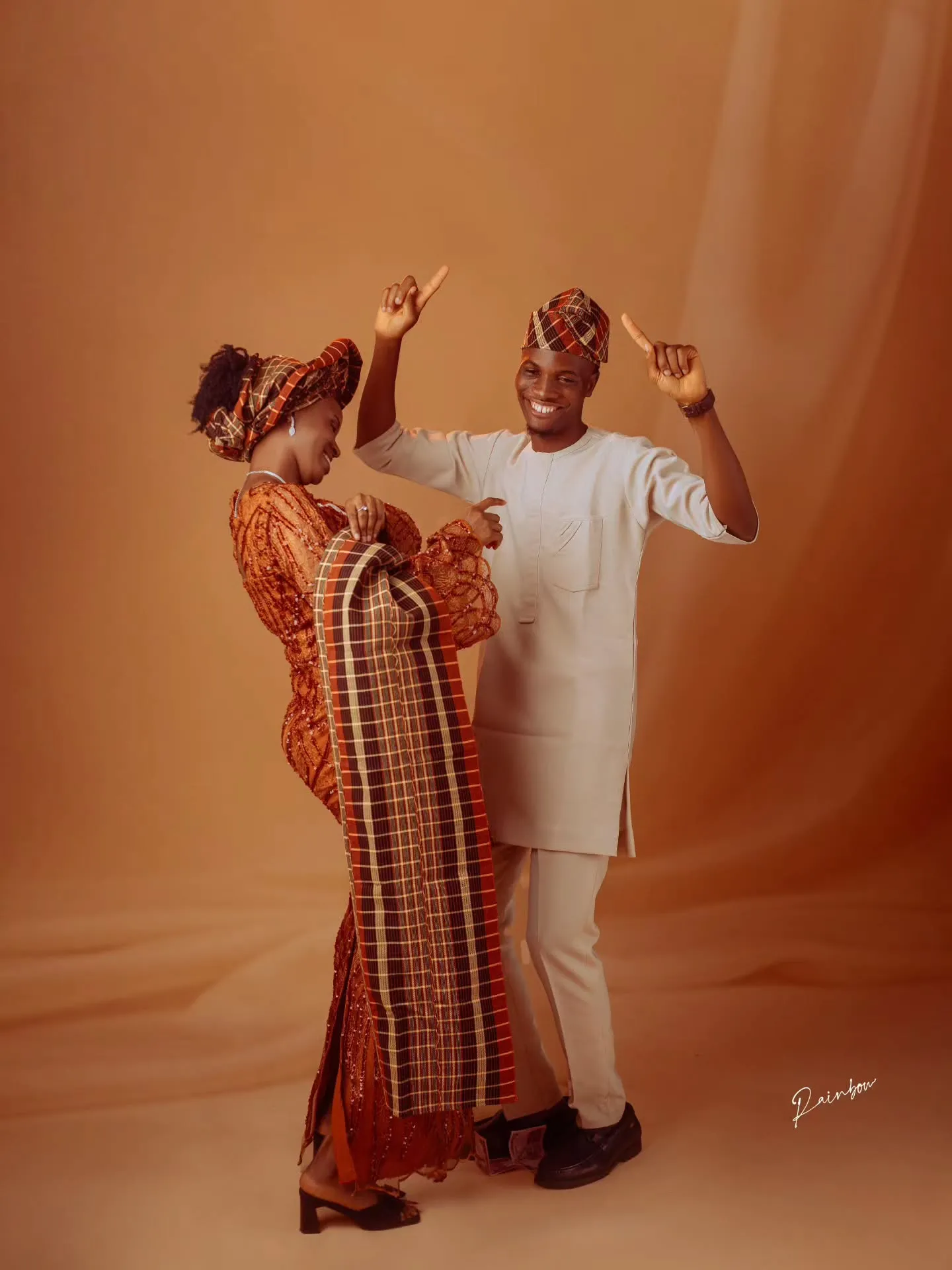 Couple dancing in matching aso-oke