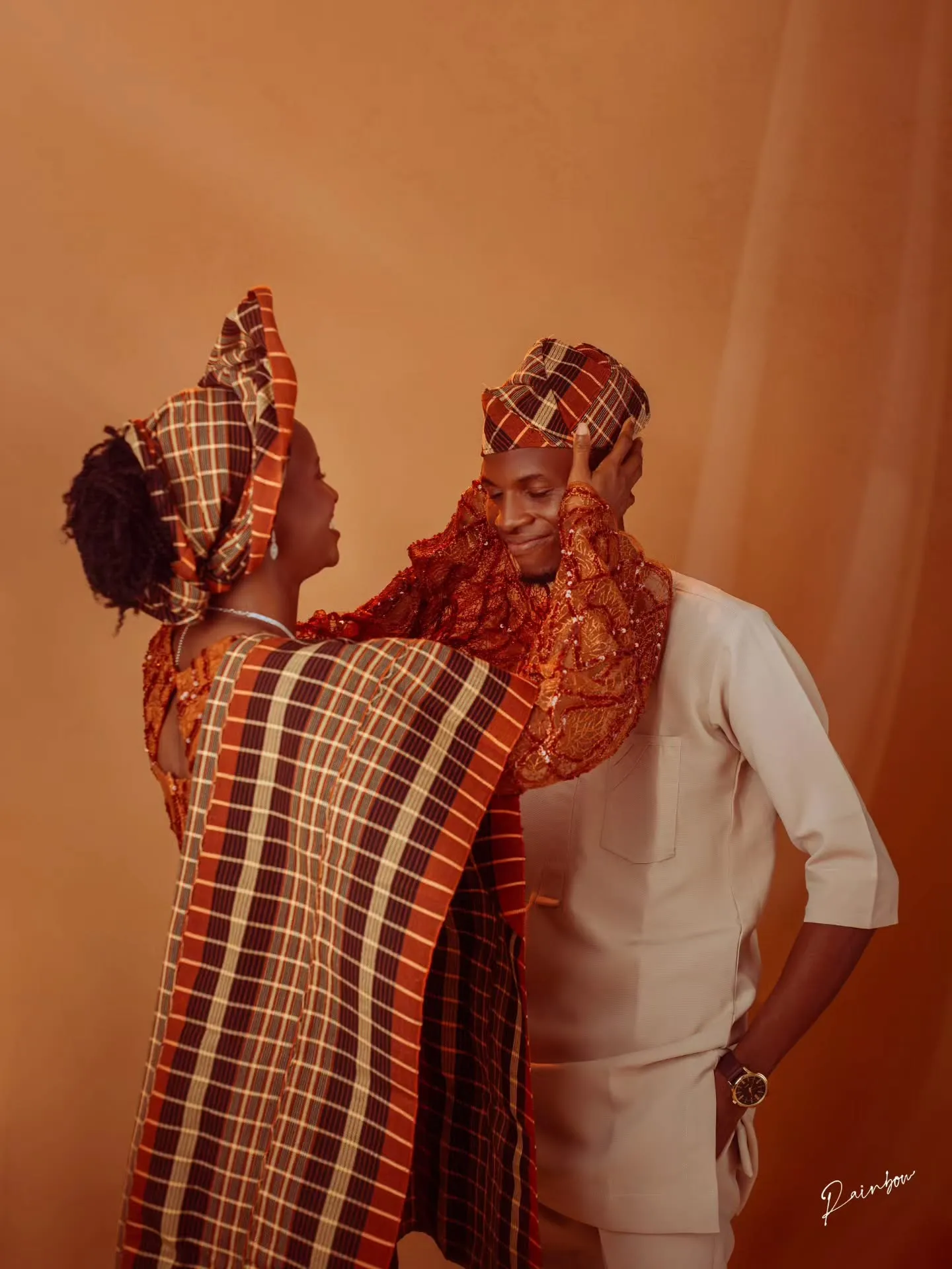 Bride adjusting her gele beside her fiancé