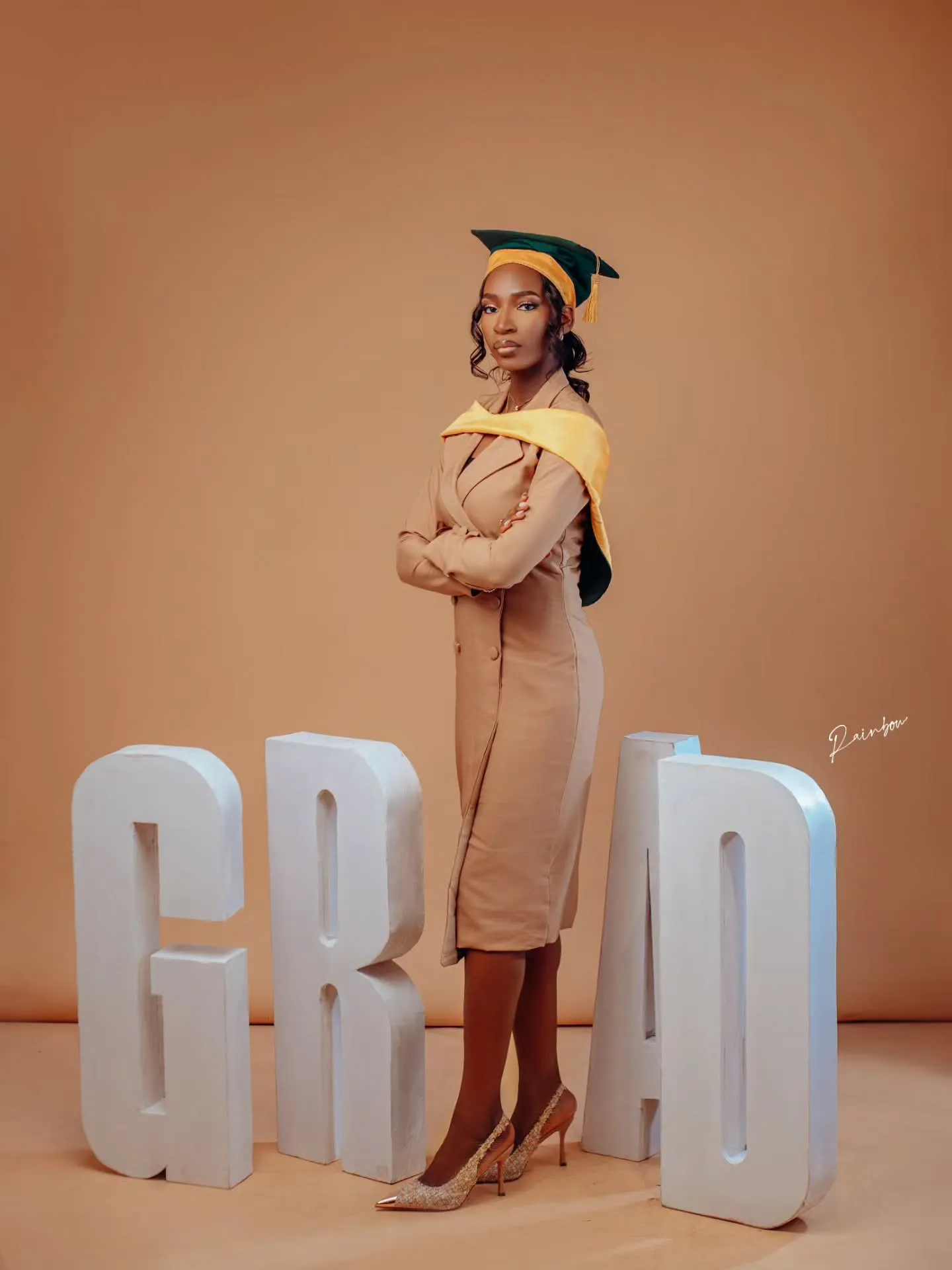 Graduate posing with giant GRAD letters