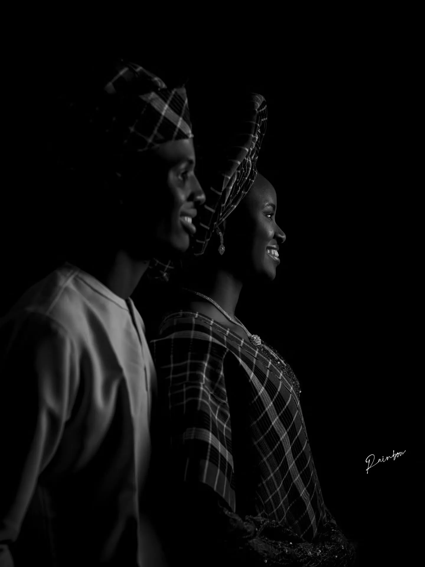 Black-and-white profile of the couple in gele and fila